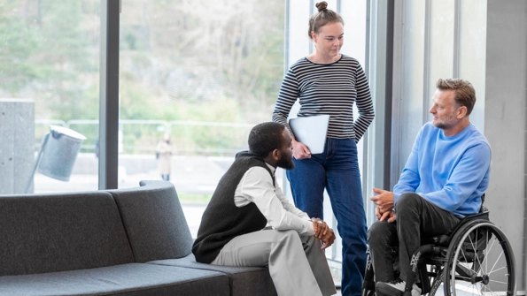 Två män och en kvinna pratar med varandra.