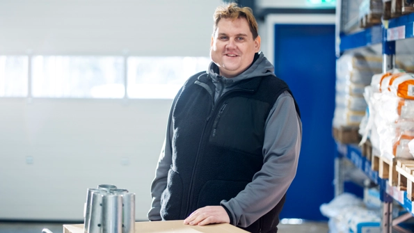 En pappa och ett barn sitter i en stentrapp. Pappan försöker ta på barnet en cykelhjälm.