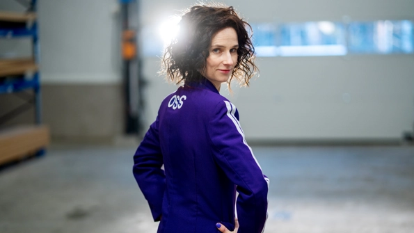 En kvinna i blå träningsoverall och mörkt hår.