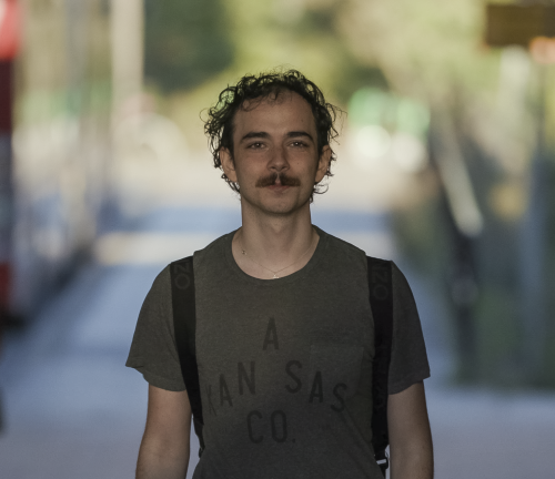 Ung kille går utomhus i stadsmiljö