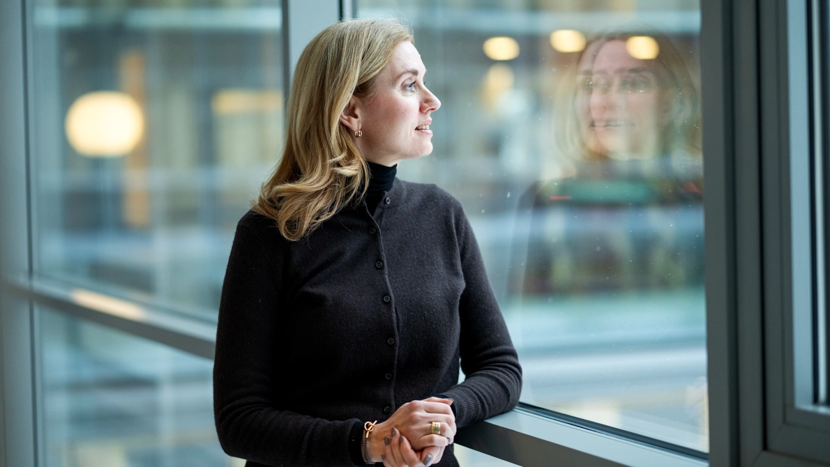 Christina Henryson, generaldirektör CSN, står i en korridor och blickar utåt genom ett fönster.