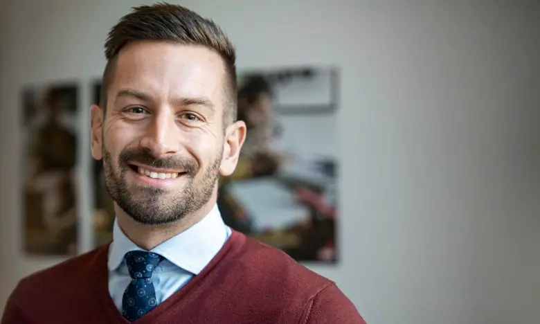 Stefan, pressekreterare på CSN syns på bild i röd tröja.